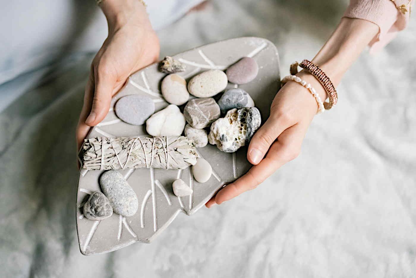 Hands holding a number of different types of stones.