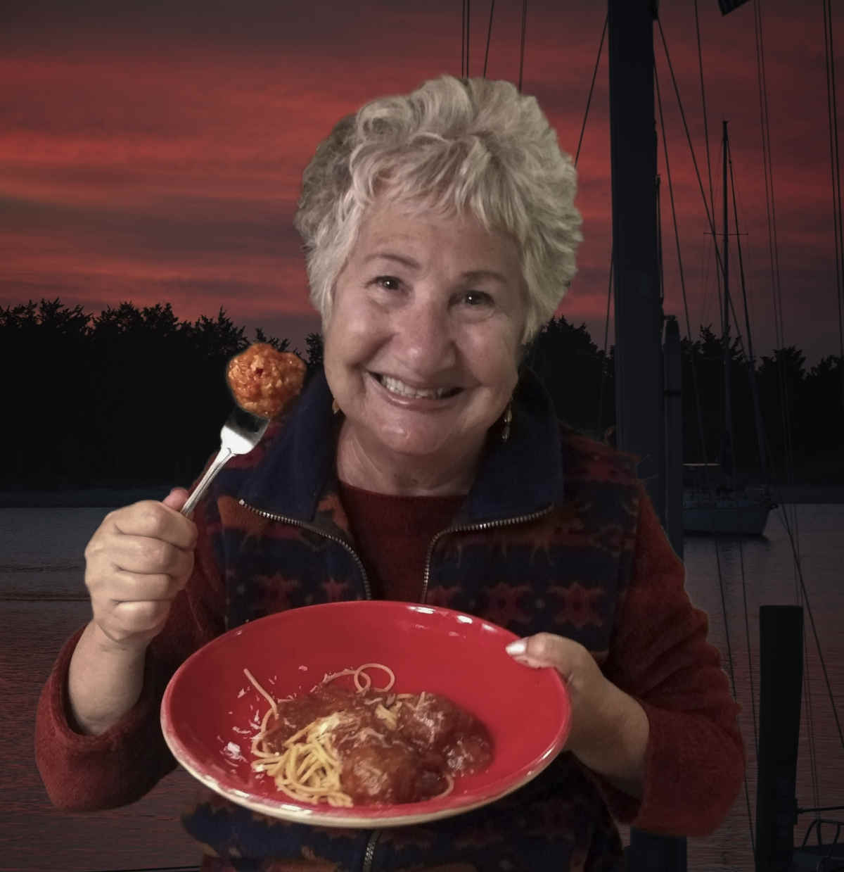 Photo of Patty Frank holding a plate of meatballs, with sunset in background.