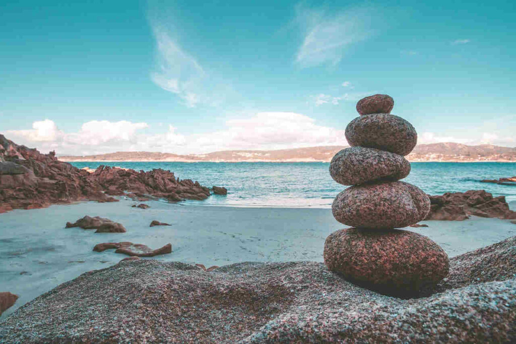 Smooth stones stacked one atop another in a seaside setting.